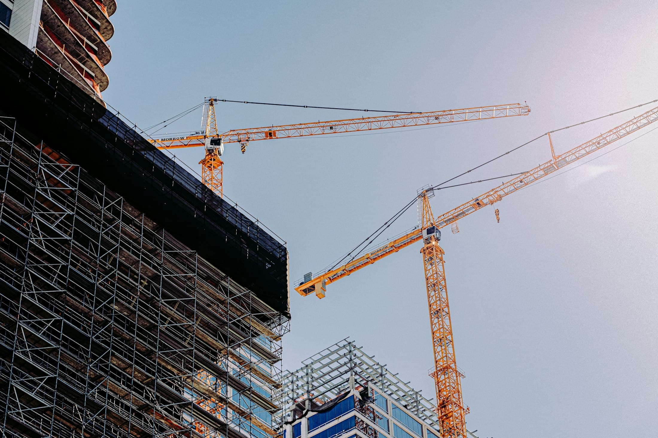 Tower cranes above a building under construction at dusk