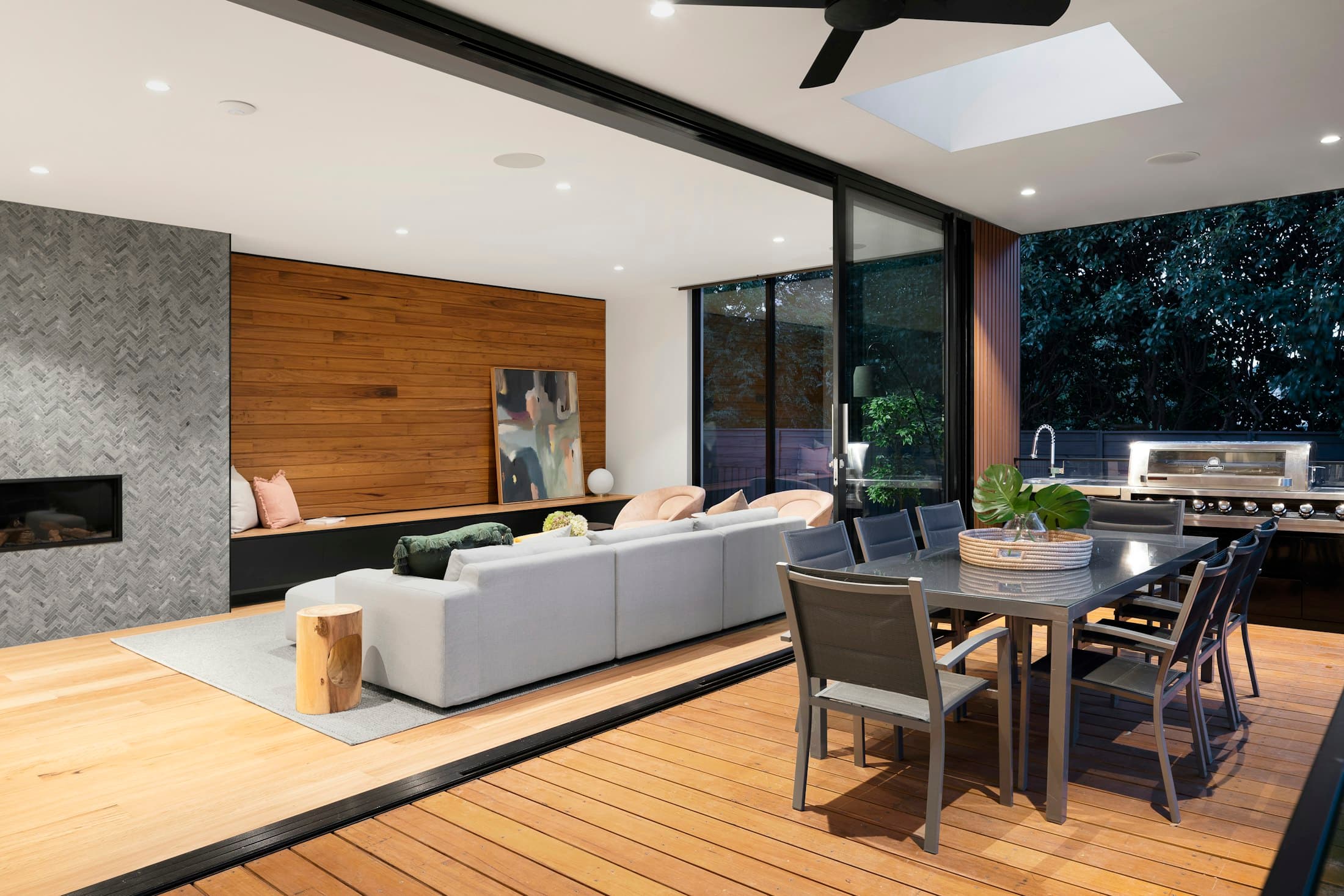 Open-plan kitchen and living area with timber wall panelling and sliding doors to the garden