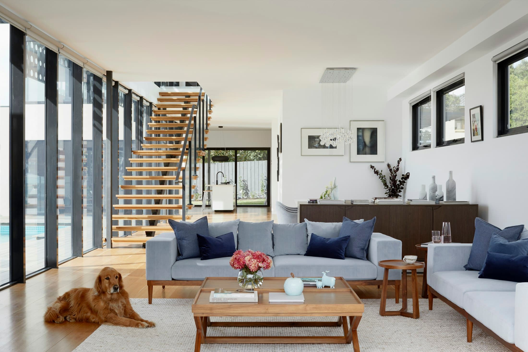 Living room with an open timber staircase and large windows