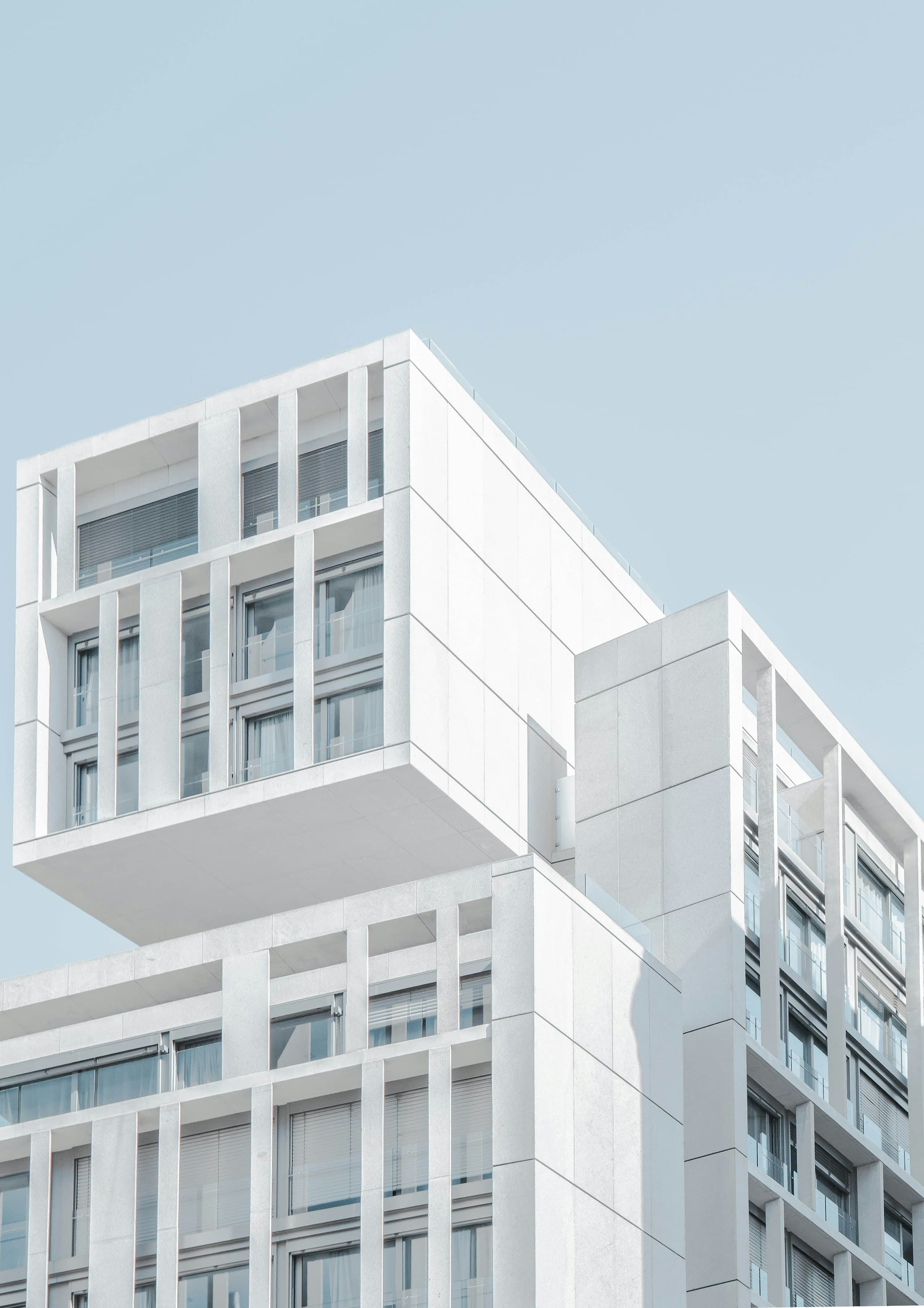White modular facade with recessed balconies and repeated window frames