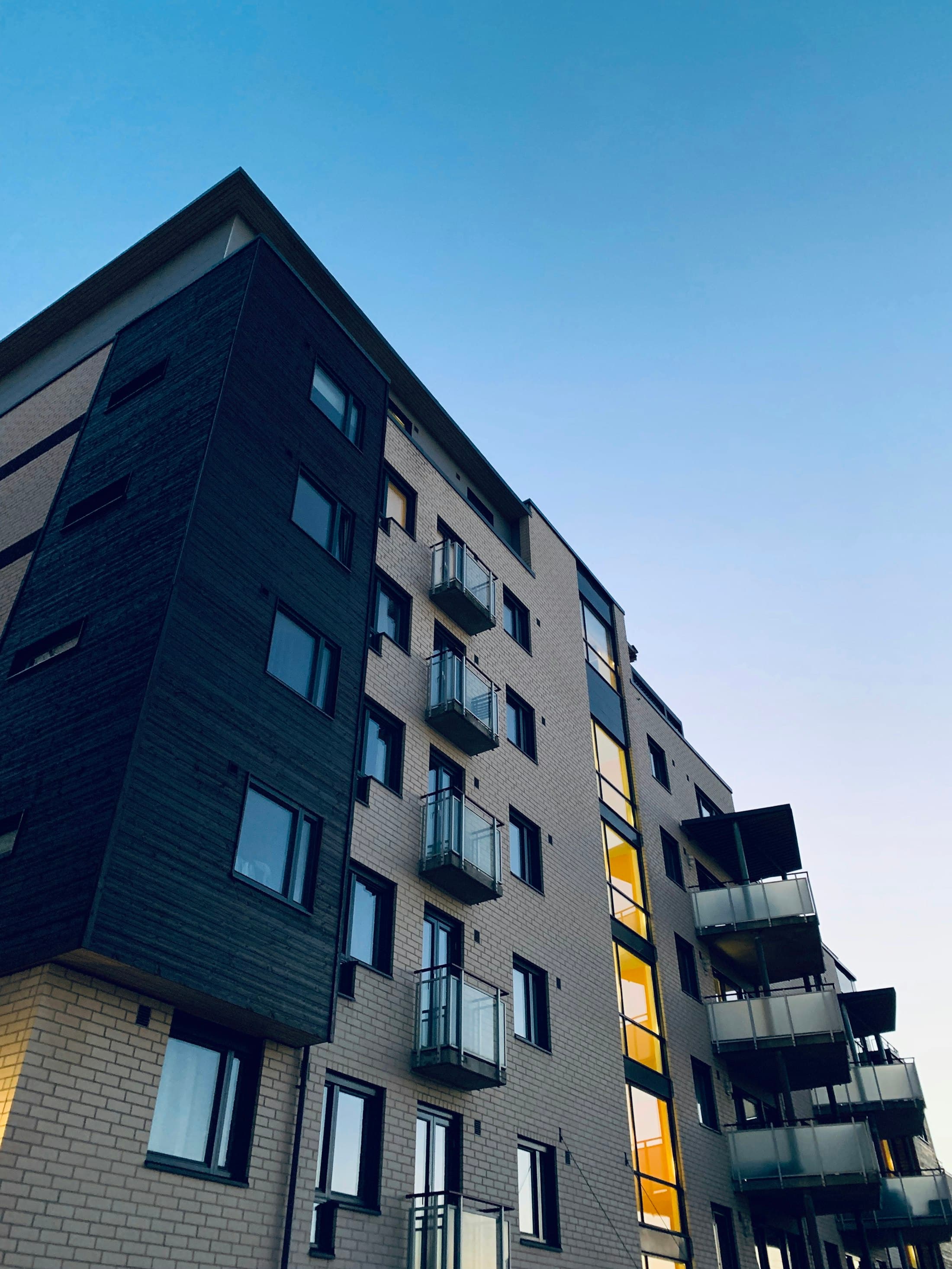 Mid-rise commercial building with dark cladding and regular window bays against a clear sky